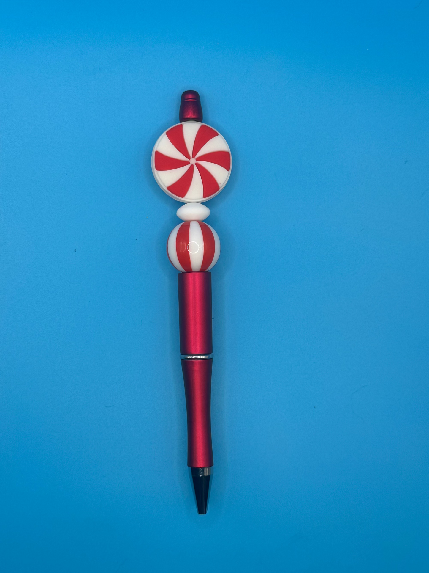 Pen with peppermint candy design on a blue background